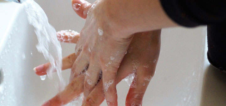 Brille reinigen mit den Händen in Wasser und Seife