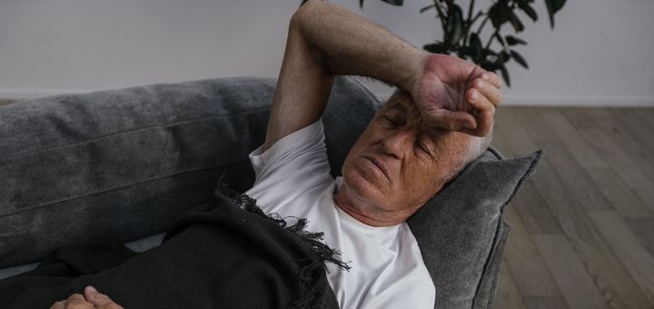 Älterer Mann auf der Couch leidet unter Nachtschweiß